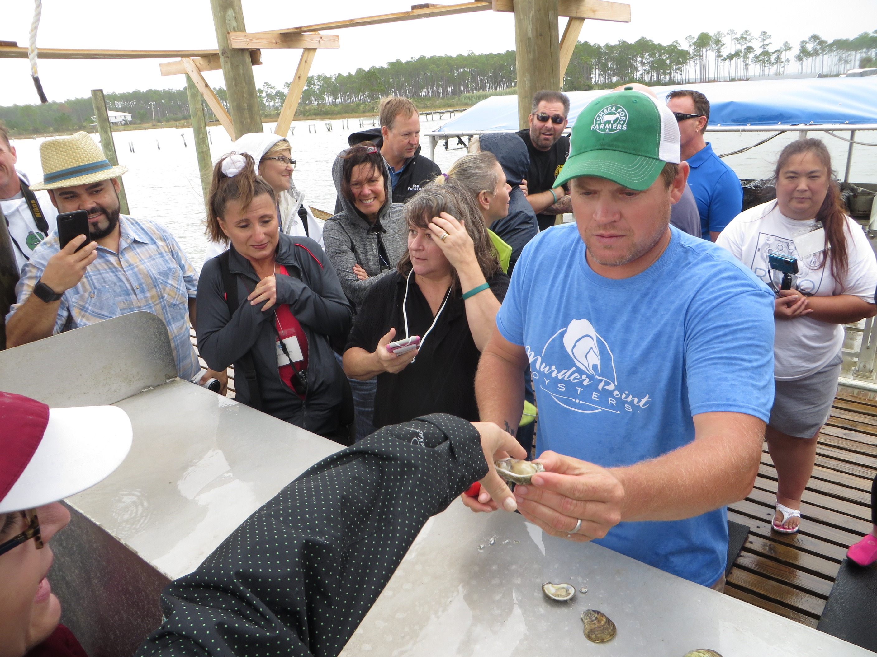Lane Zirlatt shucking oysters for the waiting tasters At Murder Point Oyster Farm Bayou la Batre