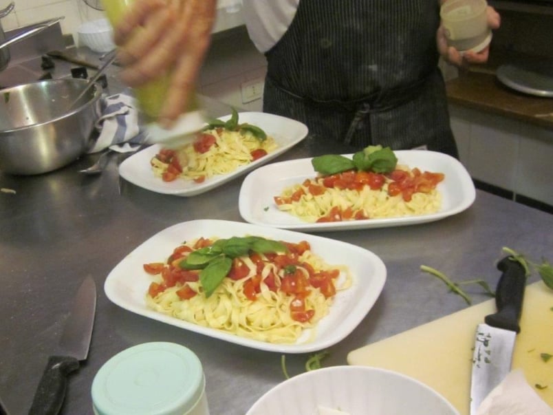 Italy - platters of fresh pasta with tomatoes and basil